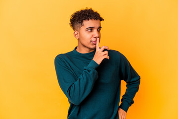 Young african american curly man isolated on purple looking sideways with doubtful and skeptical expression.