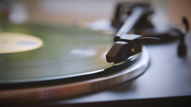 The needle goes down on a vintage vinyl record. The vinyl record is spinning. The needle plays on a vintage vinyl record. Old turntable. Vintage