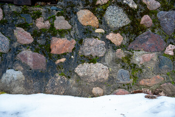part of a stone wall fence where you can see white snow
