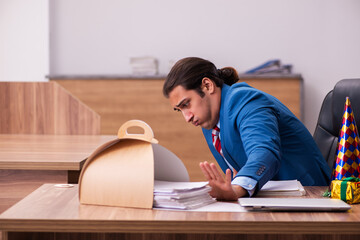 Young male employee celebrating Christmas at workplace