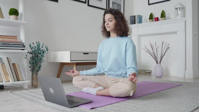 Happy Fit Young Woman Using Laptop Computer Watching Online Yoga Lesson, Fitness Video Class, Learning Virtual Meditation Training Tutorial, Doing Exercise, Feeling No Stress, Peace Of Mind At Home.