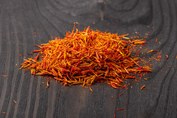 A pile of saffron stigmas on a dark wooden background