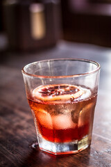 Old fashioned glass negroni cocktail alcohol drink beverage with orange slice and bokeh background