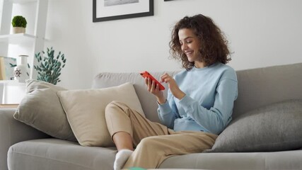 Happy hispanic teen girl holding cell phone using smartphone device at home. Smiling young latin woman blogger subscribing new social media, buying in internet, ordering products online in apps. - Powered by Adobe