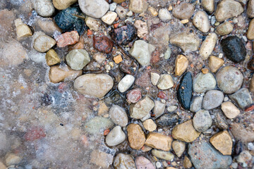 as the snow melts, colored stones are exposed that sir on the ground