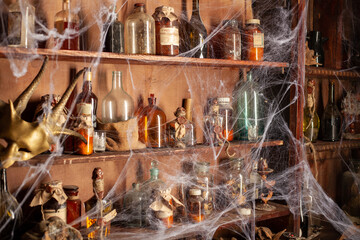 Halloween background Shelves with alchemy tools Skull spiderweb bottle with poison candles