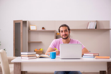 Young male student preparing for exams at home