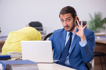 Young male employee looking after new born at workplace