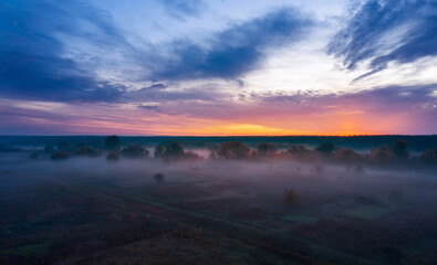 Morning landscape at sunrise with fog in a countryside field.