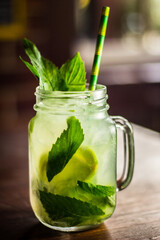 Mojito cocktail fruit alcohol drink beverage with ice straw and bokeh background 