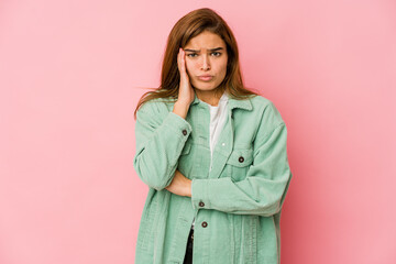 Young skinny caucasian teenager girl blows cheeks, has tired expression. Facial expression concept.