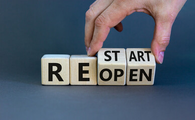 Reopen and restart symbol. Businessman hand turns cubes and changes the word 'reopen' to 'restart'....