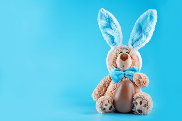 Blue background with toy bunny for Easter