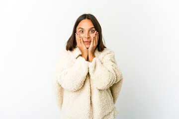 Young mixed race woman shocked, covering mouth with hands, anxious to discover something new.