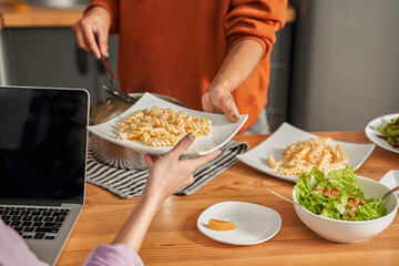 Woman giving plate with fresh pasta to her best friend