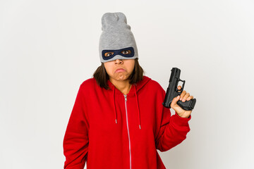 Young robber hispanic woman wearing a mask shrugs shoulders and open eyes confused.