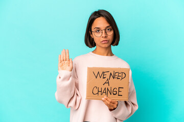 Fototapeta na wymiar Young hispanic mixed race woman holding an inspiring change message on cardboard standing with outstretched hand showing stop sign, preventing you.