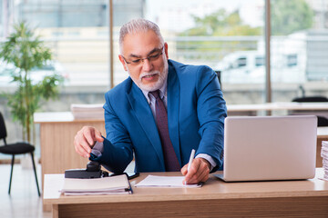 Old male boss employee working in the office