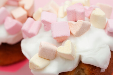 cupcake with hearts from marshmallow on a pink background closeup