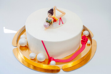 White cake with a gymnast figure. Cake for the athlete.