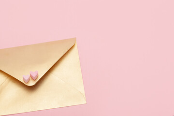Golden paper envelope with two hearts from marshmallow isolated on pink background