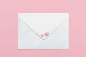 light mother-of-pearl paper craft envelope with two hearts from marshmallow isolated on pink...