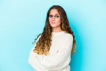 Young caucasian curly hair woman isolated suspicious, uncertain, examining you.