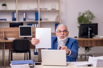 Old businessman employee after accident working in the office