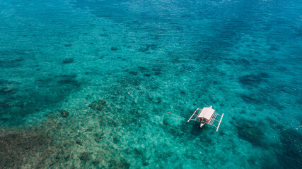 Naklejka na ściany i meble Aerial view of Philippines traditional boat sailing over blue turquoise waters