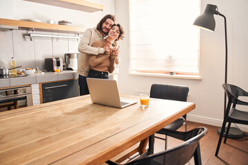 Happy loving couple embracing at the kitchen