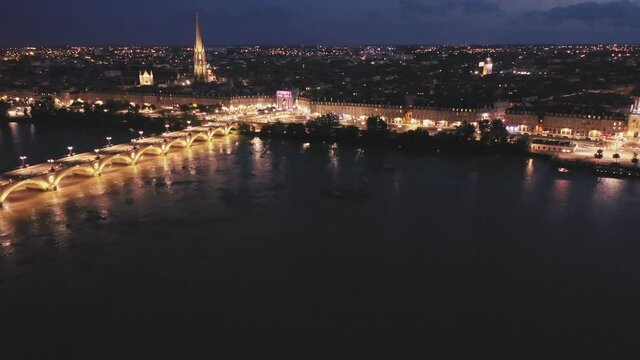 Aerial view of Bordeaux cityscape on banks of Garonne river and Pont de pierre at night