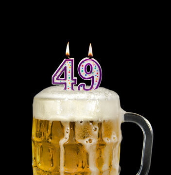 number 49 candle in beer mug for birthday celebration isolated on black 