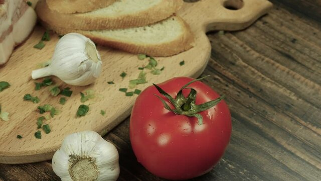 Preparing food in the kitchen, home cooking, top view fresh food on a wooden tray, bacon, appetizing tomato with ham, garlic