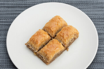 Turkish Ramadan Dessert Baklava isolated on beige plate.