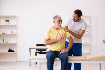 Old male patient visiting young male doctor chiropractor