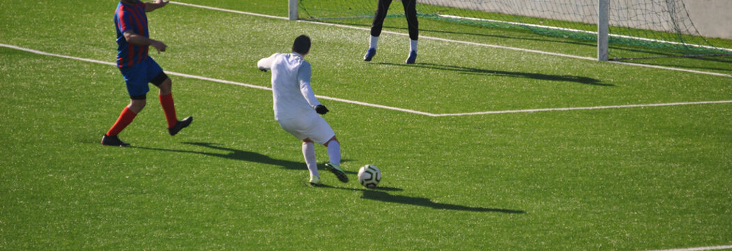 Jogo de futebol com jogador em posição de remate á baliza adversária