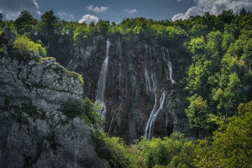 Partially hidden by cliff and forest, Veliki Slap, the tallest waterfall in Plitvice Lakes, National Park UNESCO World Heritage, Croatia