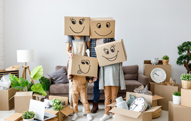 concept of moving to a new apartment and a mortgage.  funny family with boxes on their heads, on which smiley faces are painted laughing faces while packing boxes and moving