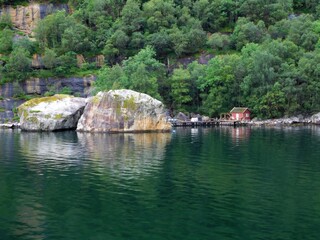 Petite cabane rouge et son ponton sur les eaux sombres d'un fjord