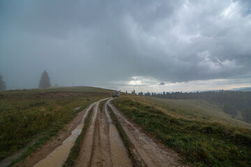 Fototapeta premium Car tour on mountains durring rainfall bad weather day