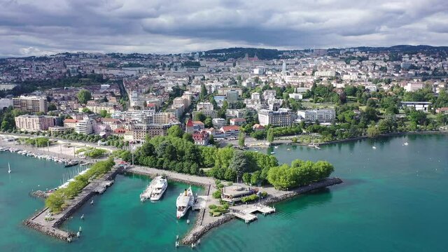 View from drone of lake Leman and houses of swiss city Lausanne in cloudy summer day