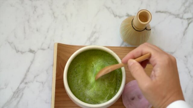 Hands holding matcha latte bowl