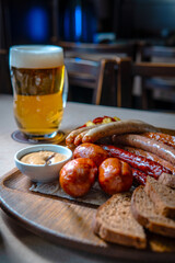 Hunting sausages on a wooden board on the table. Ketchup and mustard and brown bread next to the sausages.