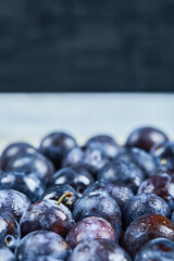 Bunch of garden plums on blue background, close up