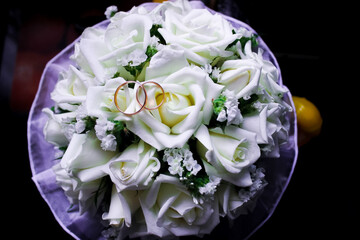 Wedding rings lie on bouquet of roses. Wedding.