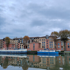 Naklejka na ściany i meble Blue steamship along the river reflected in the water during autumn, Toulouse, France