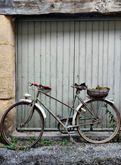 Fototapeta na wymiar Old bicycle next to the gray garage door.