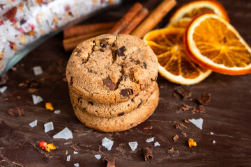 Organic food snack tasty sweet dessert milk dark chocolate chip salt cookie closeup piece fruit orange raspberry hazelnut nuts cinnamon on cocoa cacao powder wooden table for new year Christmas gift