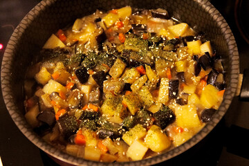 Potatoes with eggplant and carrots, cooked dish on plate.