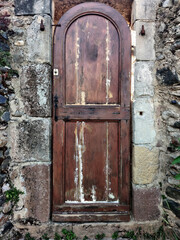 Wooden brown vintage door in the old stone building.
